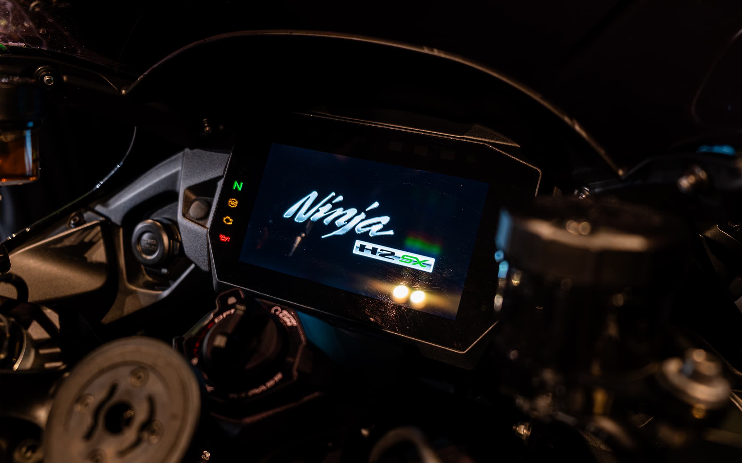 Kawasaki Ninja H2 SX SE 2024 kokpiti: analog göstergeler ve ortadaki ekranda Hayabusa amblemi